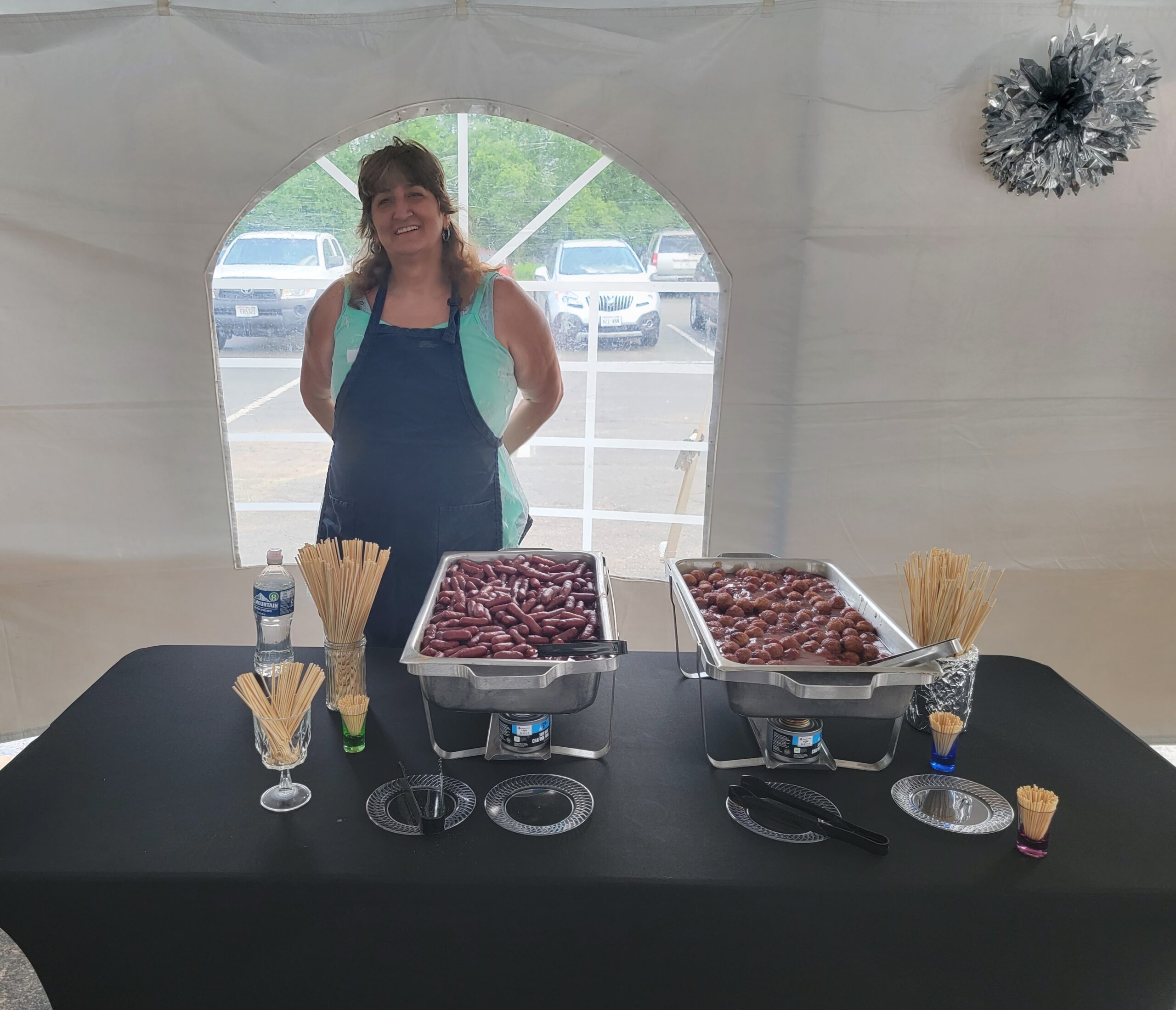 Open House - a happy volunteer serving up meaty snacks.