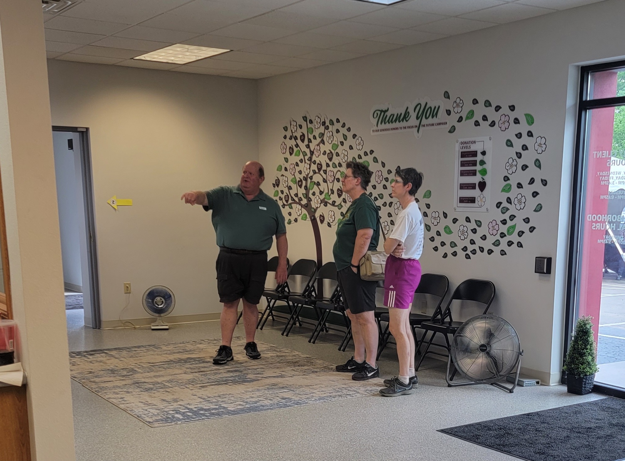 Open House - long-time board member gives some history of the origins of Feeding Our Communities with United Services (FOCUS) to touring guests.